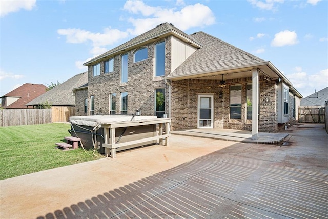 917 Erinova Dr, Yukon, OK 73099 - back of property featuring a hot tub, a patio area, a fenced backyard, brick siding, and roof with shingles