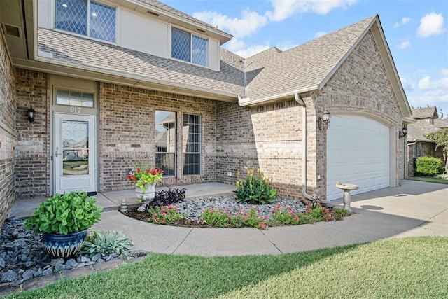 917 Erinova Dr, Yukon, OK 73099 - view of front facade with driveway, an attached garage, roof with shingles, and brick siding