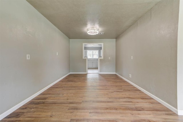 5417 NW 45th Ter, Warr Acres, OK 73122 - unfurnished room featuring light wood-type flooring and a textured ceiling