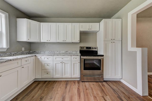 5417 NW 45th Ter, Warr Acres, OK 73122 - kitchen with stainless steel electric range, light wood-style flooring, and white cabinetry