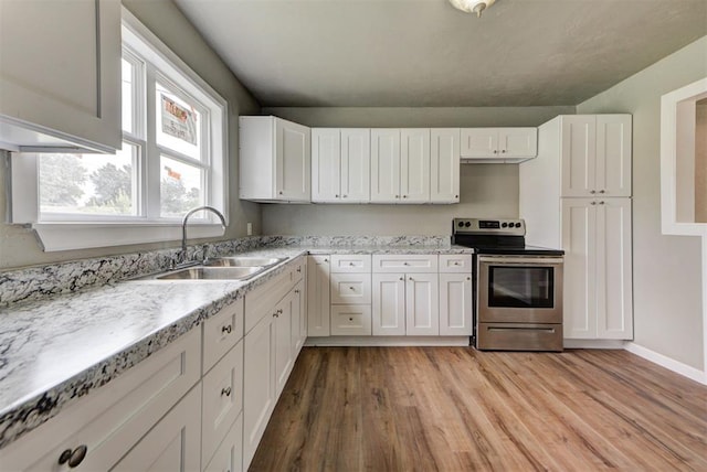 5417 NW 45th Ter, Warr Acres, OK 73122 - kitchen with stainless steel electric range oven, light wood-type flooring, white cabinets, and light stone countertops