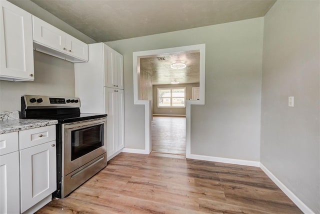 5417 NW 45th Ter, Warr Acres, OK 73122 - kitchen featuring stainless steel range with electric stovetop, light wood finished floors, white cabinets, and light stone counters