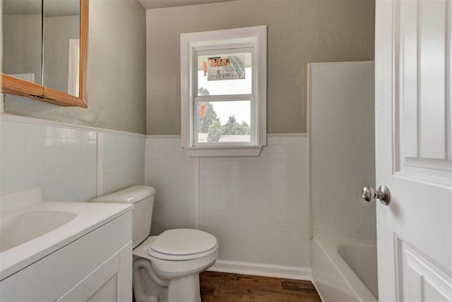 5417 NW 45th Ter, Warr Acres, OK 73122 - bathroom featuring vanity, tile walls, wood finished floors, and wainscoting
