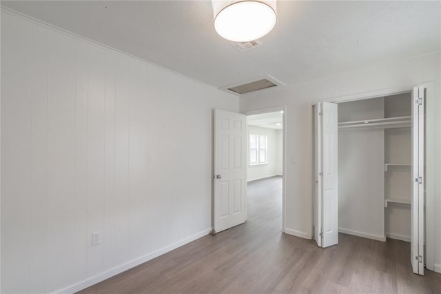 2220 SW 28th St, Oklahoma City, OK 73108 - unfurnished bedroom with wood finished floors, attic access, and a closet