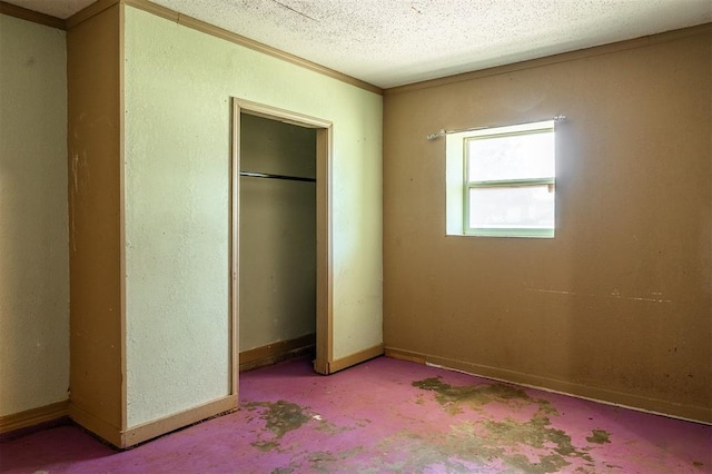 2120 E Robberts Ave, Kingfisher, OK 73750 - unfurnished bedroom featuring crown molding, a closet, and a textured ceiling