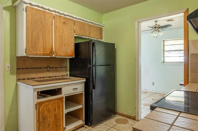 2120 E Robberts Ave, Kingfisher, OK 73750 - kitchen with freestanding refrigerator, tasteful backsplash, a ceiling fan, range with electric cooktop, and a textured ceiling