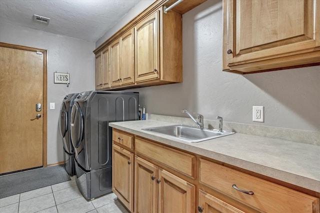 1716 NW 182nd St, Edmond, OK 73012 - washroom featuring washing machine and clothes dryer, cabinet space, light tile patterned flooring, a textured wall, and a textured ceiling