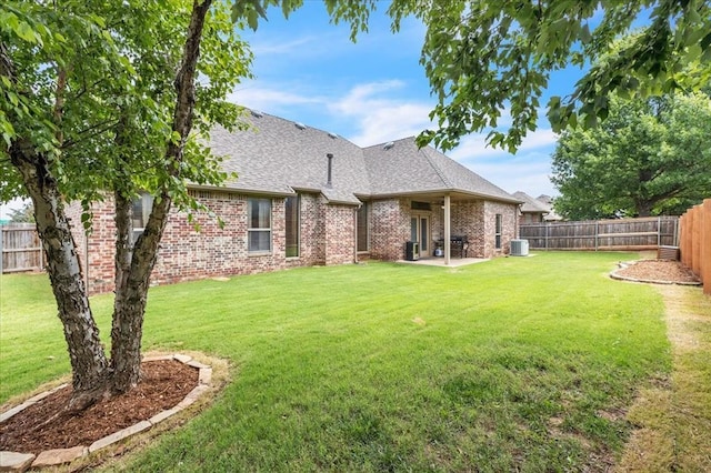 1716 NW 182nd St, Edmond, OK 73012 - back of property featuring brick siding, a fenced backyard, roof with shingles, and a patio area