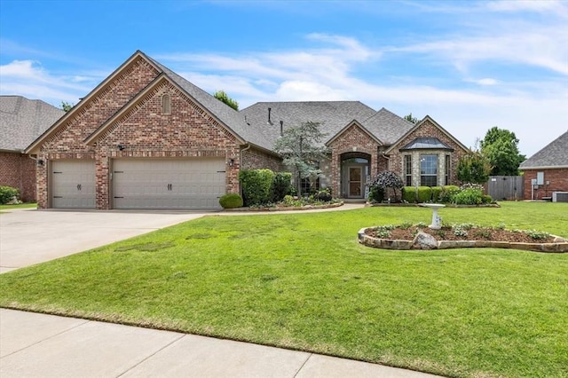 1716 NW 182nd St, Edmond, OK 73012 - french provincial home featuring brick siding, a front lawn, a garage, concrete driveway, and roof with shingles