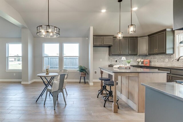 6420 SE 88th St, Oklahoma City, OK 73135 - kitchen featuring vaulted ceiling, tasteful backsplash, a center island, a chandelier, and a kitchen bar