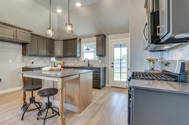 6420 SE 88th St, Oklahoma City, OK 73135 - kitchen featuring stainless steel appliances, a kitchen breakfast bar, light wood-style floors, decorative backsplash, and recessed lighting