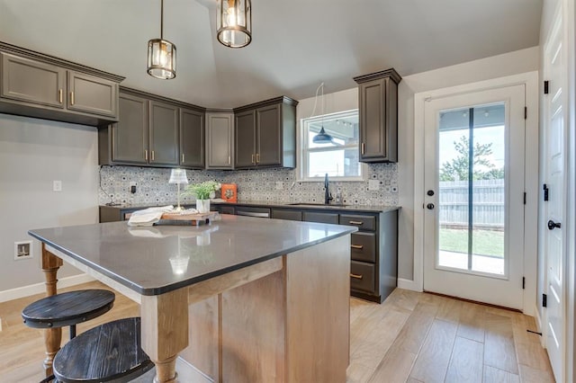 6420 SE 88th St, Oklahoma City, OK 73135 - kitchen with decorative backsplash, light wood finished floors, dark countertops, and a kitchen island