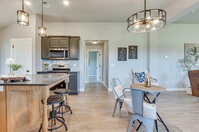 6420 SE 88th St, Oklahoma City, OK 73135 - kitchen with stainless steel microwave, a chandelier, a kitchen breakfast bar, and light wood-style floors