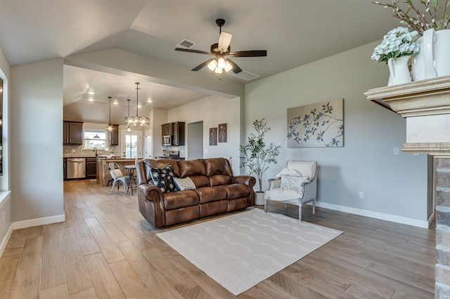 6420 SE 88th St, Oklahoma City, OK 73135 - living area featuring light wood finished floors, ceiling fan, vaulted ceiling, a fireplace, and a chandelier