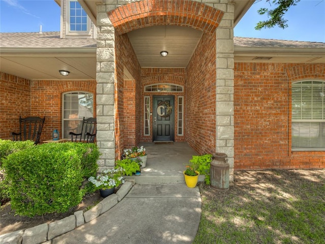 9021 NW 81st St, Yukon, OK 73099 - entrance to property featuring brick siding, covered porch, a shingled roof, and stone siding