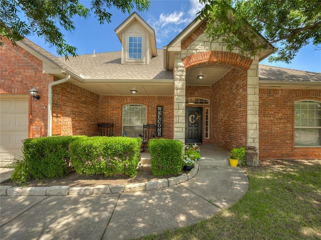 9021 NW 81st St, Yukon, OK 73099 - property entrance with a shingled roof, brick siding, an attached garage, and covered porch