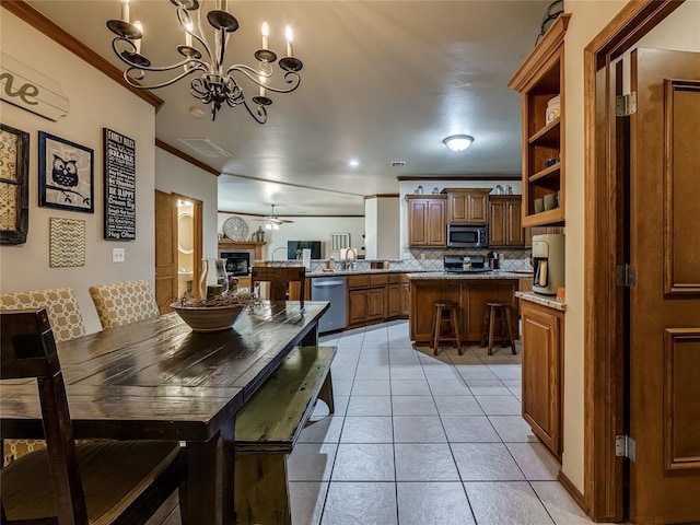 9021 NW 81st St, Yukon, OK 73099 - dining space featuring ornamental molding, a chandelier, light tile patterned floors, and a ceiling fan