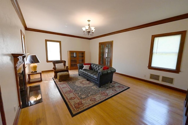 1712 W University Ave, Stillwater, OK 74074 - living room featuring light wood finished floors, a chandelier, and crown molding