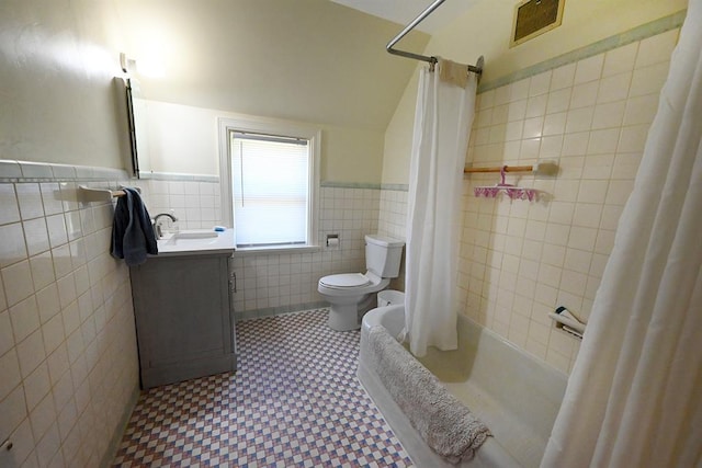 1712 W University Ave, Stillwater, OK 74074 - bathroom with tile walls, vanity, wainscoting, shower / tub combo, and lofted ceiling