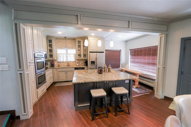 2202 NW 45th St, Oklahoma City, OK 73112 - kitchen with stainless steel appliances, a kitchen bar, backsplash, glass insert cabinets, and a center island