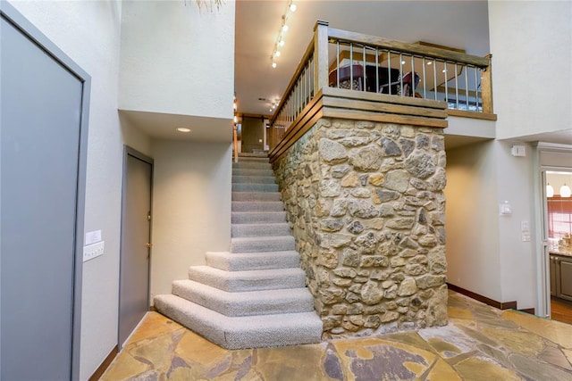 2202 NW 45th St, Oklahoma City, OK 73112 - staircase featuring a towering ceiling, stone finish floors, and track lighting
