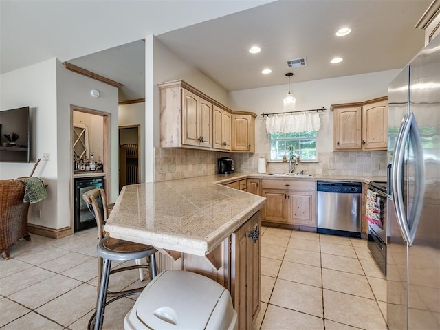 56201 E 285th Rd Unit F36, Afton, OK 74331 - kitchen with appliances with stainless steel finishes, light tile patterned floors, a kitchen breakfast bar, light brown cabinetry, and tasteful backsplash