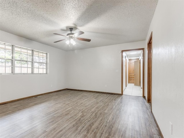5901 Seminole Rd, Warr Acres, OK 73132 - spare room with wood finished floors, ceiling fan, and a textured ceiling