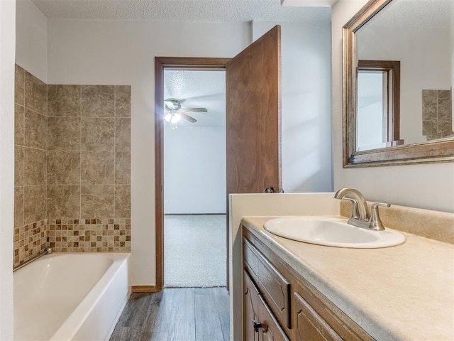 5901 Seminole Rd, Warr Acres, OK 73132 - full bathroom with wood finished floors, vanity, ceiling fan, bathing tub / shower combination, and a textured ceiling