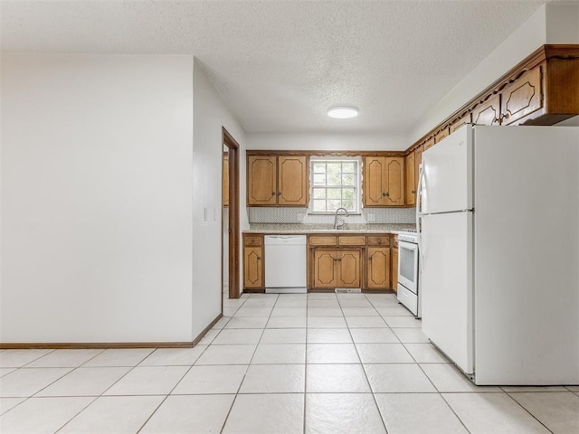 5901 Seminole Rd, Warr Acres, OK 73132 - kitchen featuring white appliances, light countertops, brown cabinetry, a textured ceiling, and light tile patterned floors