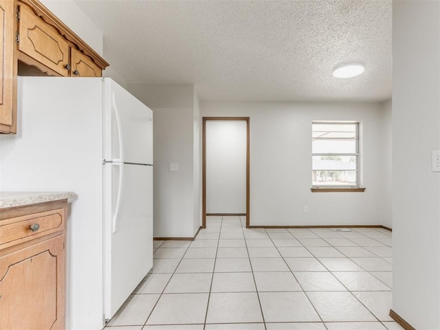5901 Seminole Rd, Warr Acres, OK 73132 - kitchen with freestanding refrigerator, a textured ceiling, and light countertops