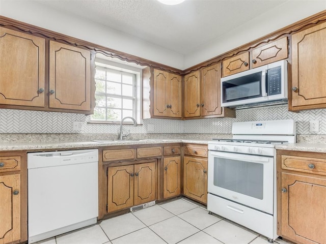 5901 Seminole Rd, Warr Acres, OK 73132 - kitchen featuring white appliances, brown cabinets, light countertops, and decorative backsplash