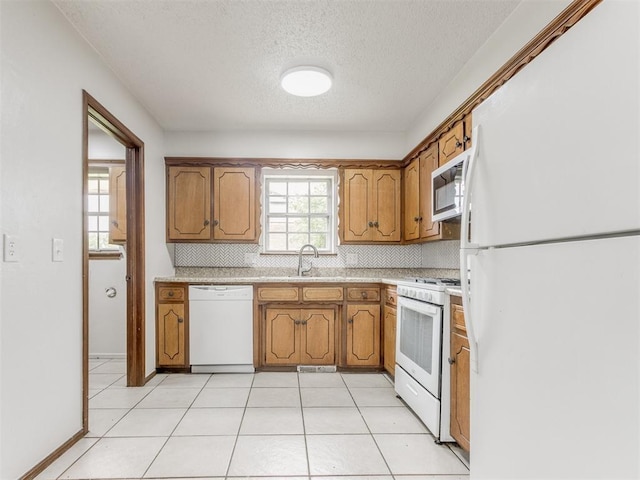 5901 Seminole Rd, Warr Acres, OK 73132 - kitchen with white appliances, a textured ceiling, decorative backsplash, light countertops, and brown cabinetry