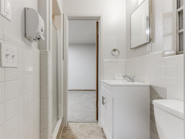 5901 Seminole Rd, Warr Acres, OK 73132 - full bathroom with tile walls, vanity, a shower stall, a wainscoted wall, and tile patterned flooring