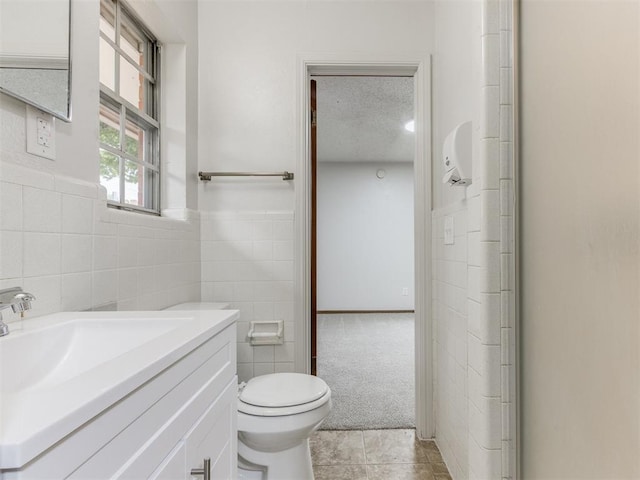 5901 Seminole Rd, Warr Acres, OK 73132 - bathroom featuring tile walls, vanity, tile patterned flooring, and a textured ceiling