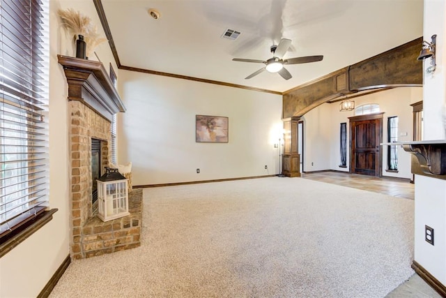 921 Tea Rose Dr, Yukon, OK 73099 - unfurnished living room featuring a fireplace, arched walkways, carpet, ceiling fan, and crown molding