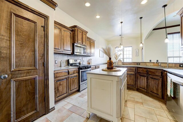 921 Tea Rose Dr, Yukon, OK 73099 - kitchen featuring appliances with stainless steel finishes, healthy amount of natural light, recessed lighting, arched walkways, and pendant lighting