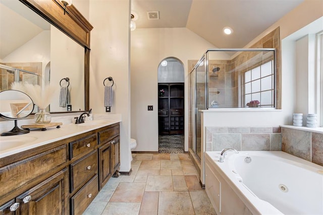 921 Tea Rose Dr, Yukon, OK 73099 - bathroom featuring lofted ceiling, double vanity, a whirlpool tub, a shower stall, and stone finish flooring