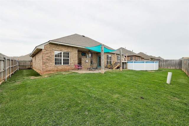 921 Tea Rose Dr, Yukon, OK 73099 - rear view of property featuring brick siding, a fenced backyard, and a patio