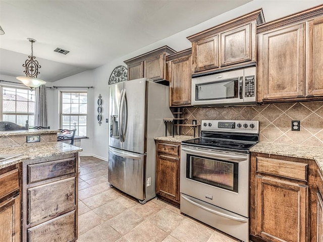 516 SW 161st St, Oklahoma City, OK 73170 - kitchen with stainless steel appliances, backsplash, vaulted ceiling, hanging light fixtures, and light stone counters