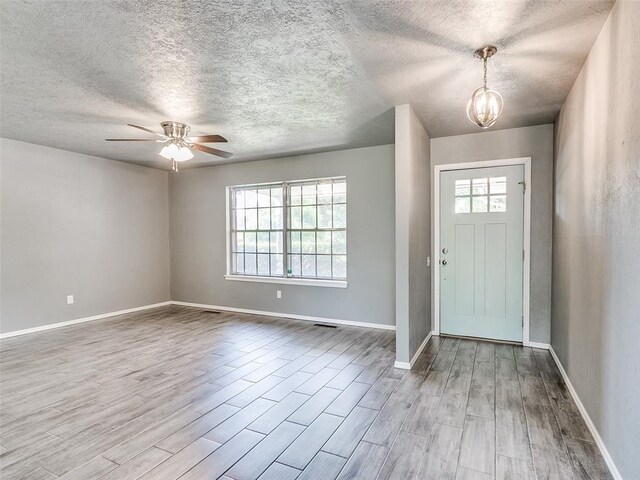 1917 Barryton Rd, Oklahoma City, OK 73120 - foyer with healthy amount of natural light, a textured ceiling, wood finished floors, a chandelier, and a ceiling fan