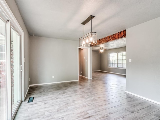 1917 Barryton Rd, Oklahoma City, OK 73120 - spare room featuring a ceiling fan, light wood-style flooring, a chandelier, and a textured ceiling