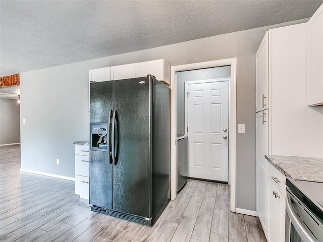 1917 Barryton Rd, Oklahoma City, OK 73120 - kitchen with black refrigerator with ice dispenser, wood tiled floors, white cabinetry, stove, and a textured ceiling