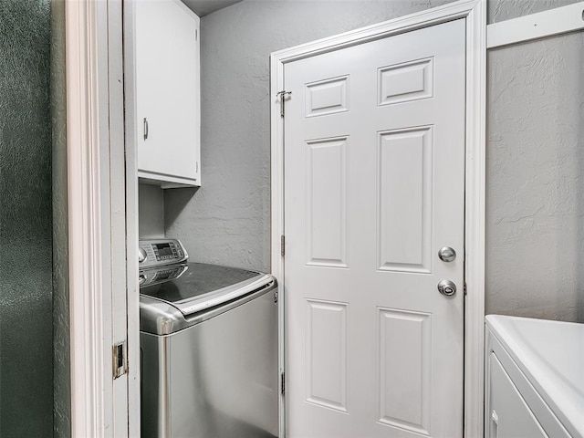 1917 Barryton Rd, Oklahoma City, OK 73120 - washroom with a textured wall, cabinet space, and washing machine and dryer