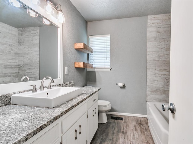 1917 Barryton Rd, Oklahoma City, OK 73120 - bathroom featuring vanity, wood finished floors, a textured ceiling, and a textured wall