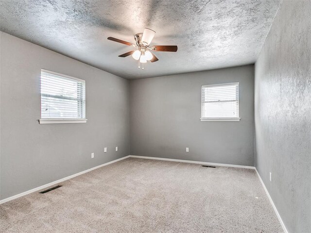 1917 Barryton Rd, Oklahoma City, OK 73120 - carpeted spare room featuring plenty of natural light, a ceiling fan, and a textured ceiling
