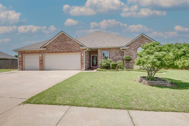 4621 Deer Ridge Blvd, Yukon, OK 73099 - view of front of property featuring an attached garage, concrete driveway, a front yard, and brick siding
