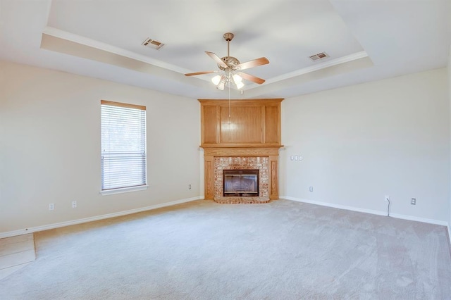 4621 Deer Ridge Blvd, Yukon, OK 73099 - unfurnished living room with a raised ceiling, a ceiling fan, light colored carpet, a glass covered fireplace, and crown molding
