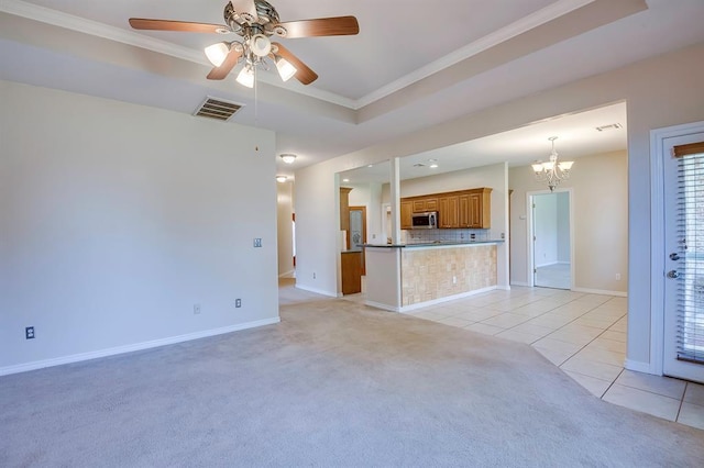 4621 Deer Ridge Blvd, Yukon, OK 73099 - unfurnished living room with crown molding, light tile patterned floors, light carpet, a ceiling fan, and a chandelier