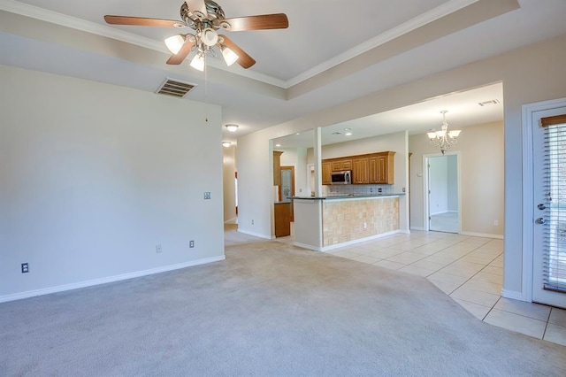4621 Deer Ridge Blvd, Yukon, OK 73099 - unfurnished living room featuring crown molding, light tile patterned floors, light carpet, a chandelier, and a ceiling fan