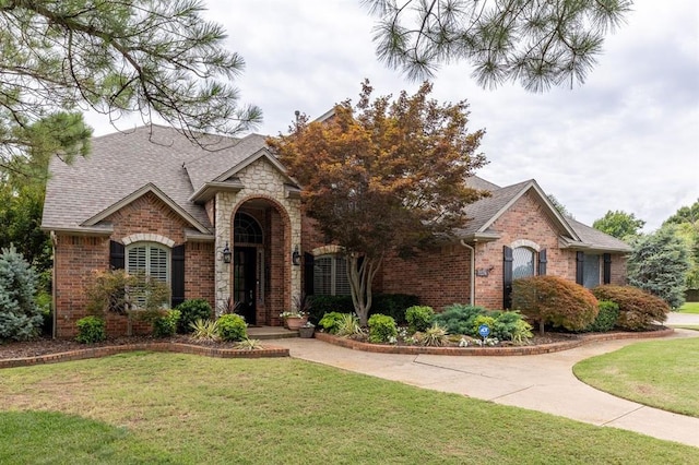 4719 W Two Lakes Ave, Norman, OK 73072 - view of front of home with brick siding, a front yard, stone siding, and roof with shingles